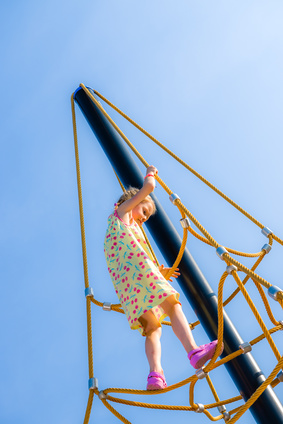 Young girl on the jungle gym, sunny day